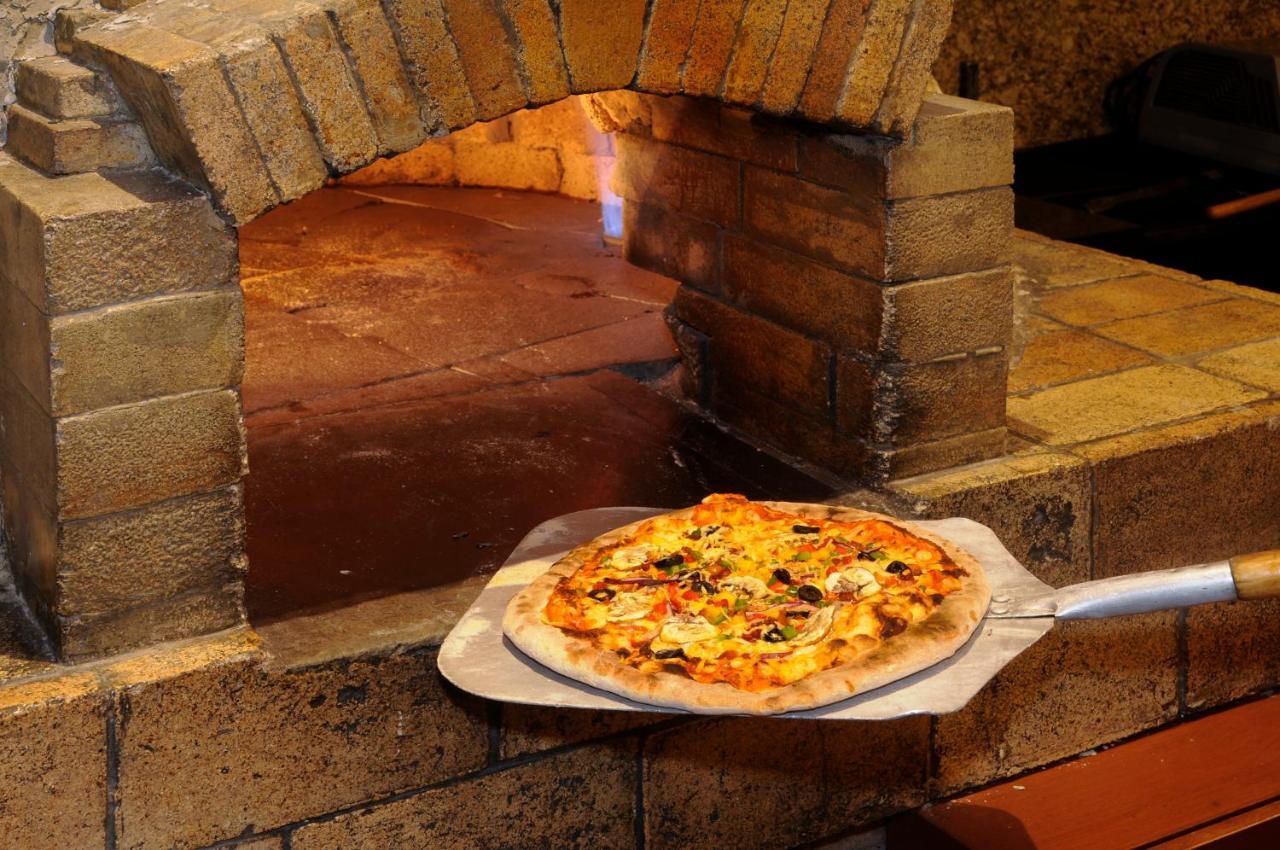 โรงแรมคราวน์ พลาซา เด เม็กซิโก เม็กซิโกซิตี้ ภายนอก รูปภาพ Pizza being removed from a wood-fired oven